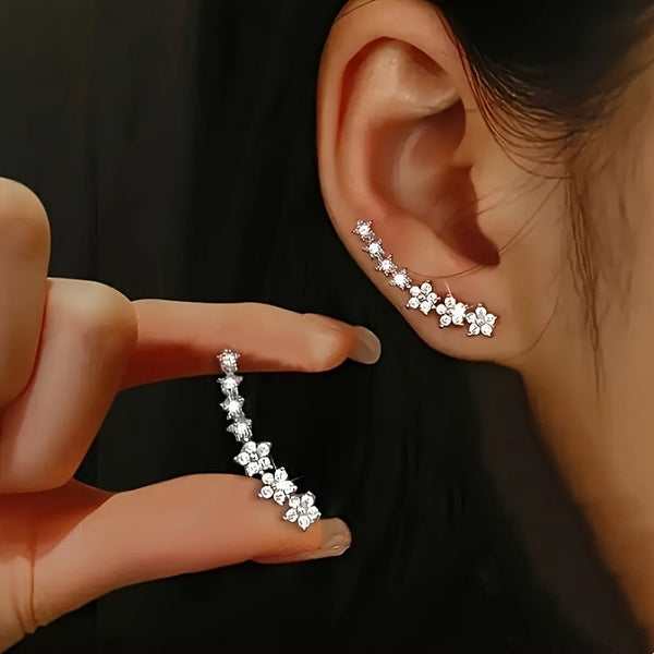 Pendientes trepadores con pequeñas flores brillantes sobre la oreja