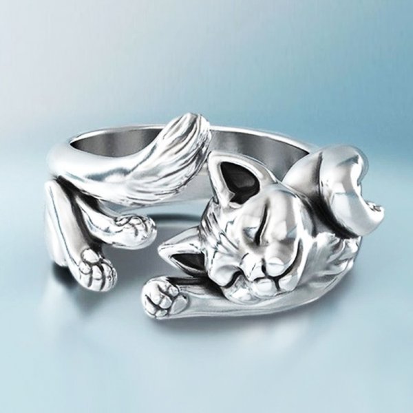 Anillo en acabado plateado esculpido como un gato tumbado que rodea el dedo, con las patas estiradas y la cabeza apoyada