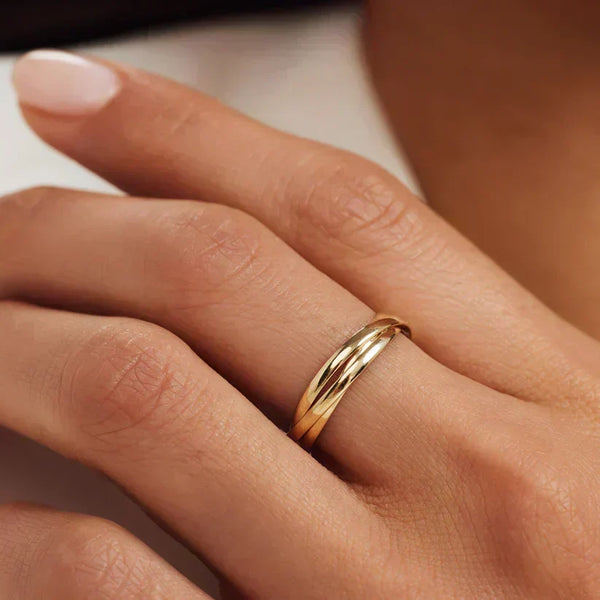 Anillo fino y sencillo en acabado dorado en la mano