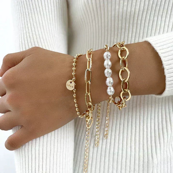 Conjunto de pulseras finas apiladas en la muñeca