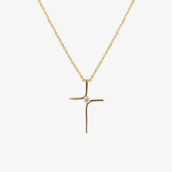 Collar de cadena fina en acabado dorado con una cruz estrecha de trazo curvo y una sola piedra transparente en el cruce