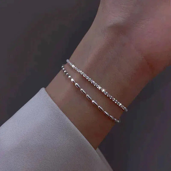 Conjunto de dos pulseras finas con cristales en la muñeca