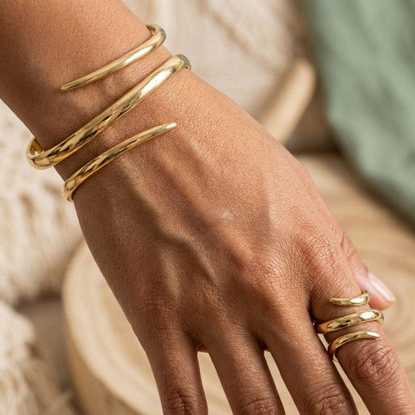 Pulsera y anillo a juego en acabado dorado, los dos formados por una banda martillada que da varias vueltas sobre sí misma
