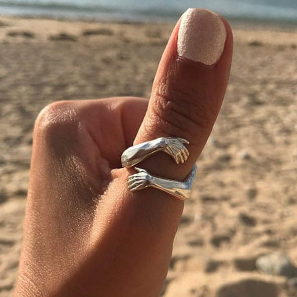 Anillo abierto con dos brazos que abrazan el dedo, acabado plateado