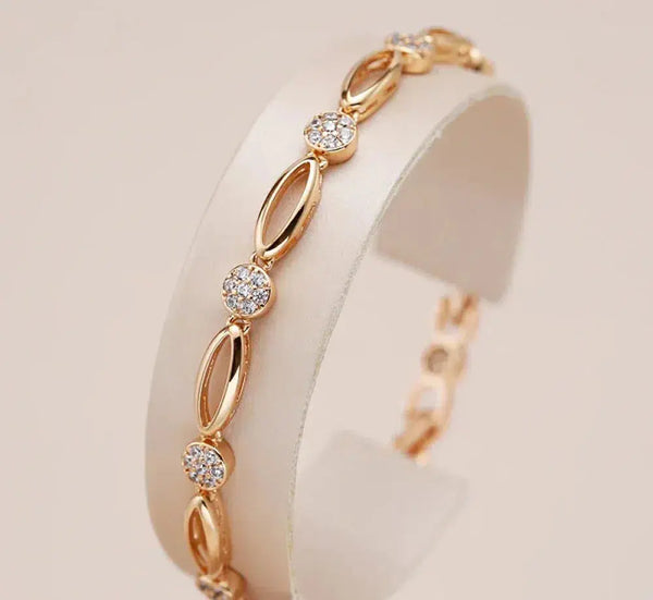 Pulsera fina con circonita y acabado dorado en la muñeca