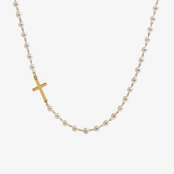 Collar de cadena fina con pequeñas perlas de agua dulce y una cruz dorada colocada de lado en la parte delantera