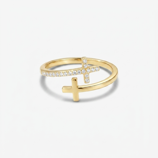 Anillo dorado de banda partida en dos aros, con una cruz lisa en el aro inferior y otra cruz cuajada de piedras diminutas en el superior